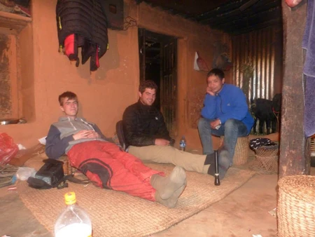 Three people sitting and relaxing in a rustic room.
