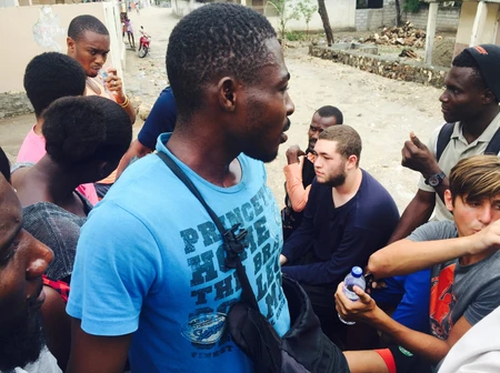 A group of people engaged in conversation outdoors.