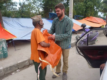 A man warmly shaking hands with a child in a vibrant outdoor setting.