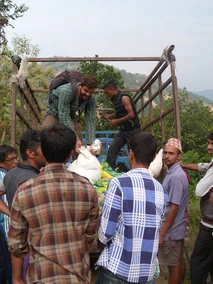 People loading supplies onto a truck in a rural area.