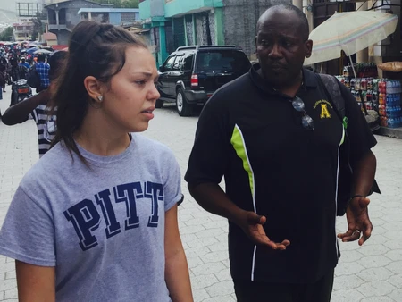 Two people conversing while walking on a city street.