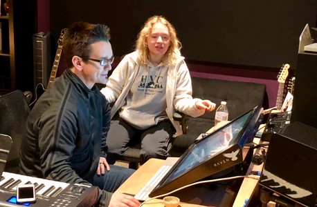 Two people collaborating on digital art using a drawing tablet.