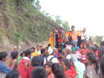 Crowd gathered outdoors on a hillside during a community event.