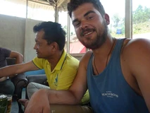 Two men sitting indoors, one smiling at the camera.