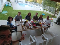Group of friends enjoying a meal outdoors by a poolside.