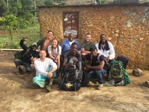Group of people smiling together outdoors with backpacks.