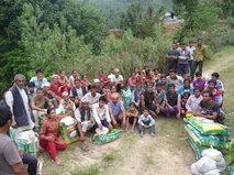 A large group of people gathered outdoors in a rural setting.
