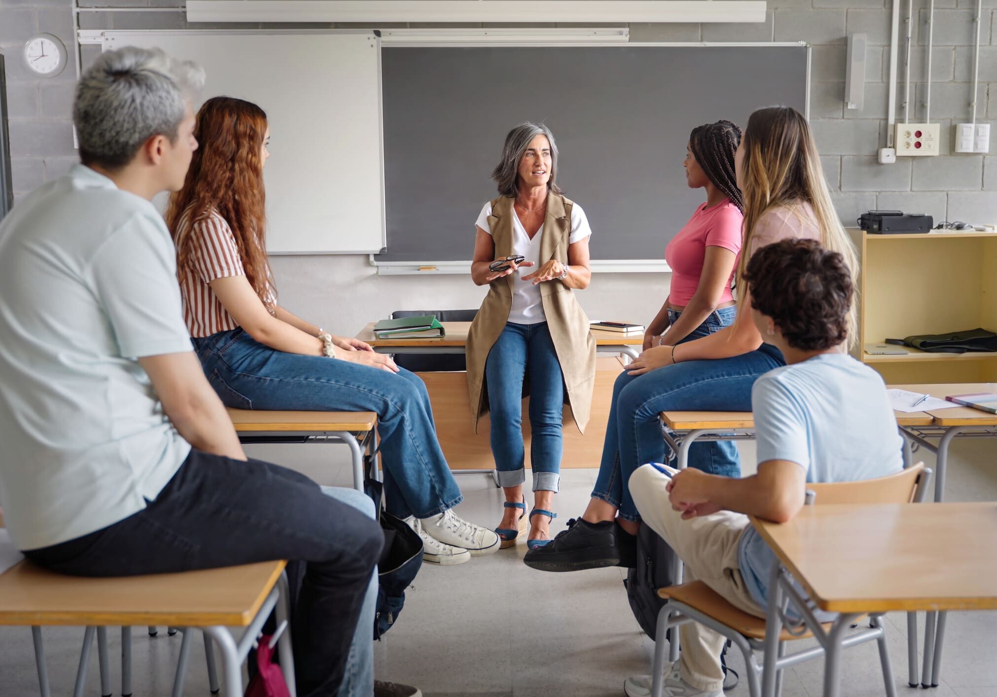 Teacher leading discussion with students in classroom.